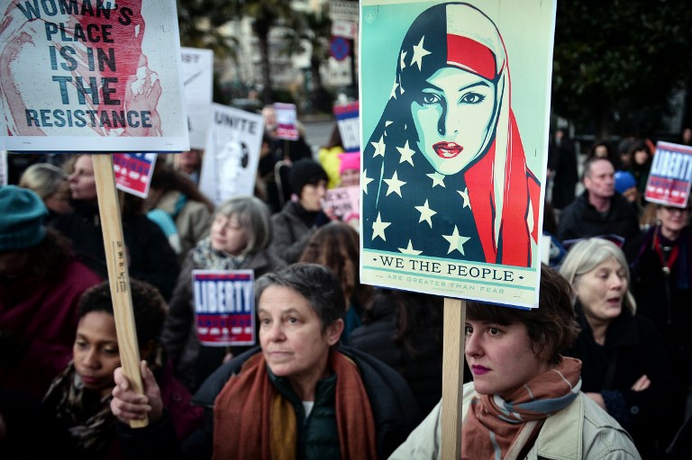 TO GO WITH AFP STORY BY JESSICA LOPEZ (FILES) This file photo taken on January 21, 2017 shows women holding placards during an demonstration in front of the US embassy in Athens, in solidarity with the Women's March on Washington, one day after the inauguration of Donald Trump as US President.  The 40th International Women's Day will be marked on March 8, 2017. / AFP PHOTO / LOUISA GOULIAMAKI