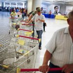 Customers line up to get in for shopping at a state-run Bicentenario supermarket in Caracas