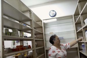 A pharmacy employee arranges medicines at a shelf in a drugstore in Caracas January 20, 2016. REUTERS/Carlos Garcia Rawlins