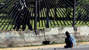 A member of the riot security forces points a gun through the fence of an air base at an opposition supporter during clashes at a rally against Venezuelan President Nicolas Maduro's government in Caracas, Venezuela June 22, 2017. REUTERS/Carlos Garcia Rawlins