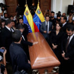 People stand next to the coffin of the opposition lawmaker Fernando Alban during a ceremony at the National Assembly in Caracas